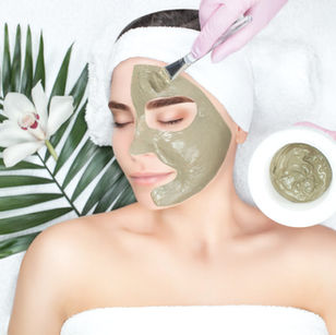 Client receiving a botanical clay facial mask