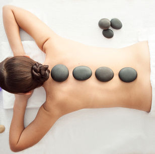 Hot stones arranged along a client's back